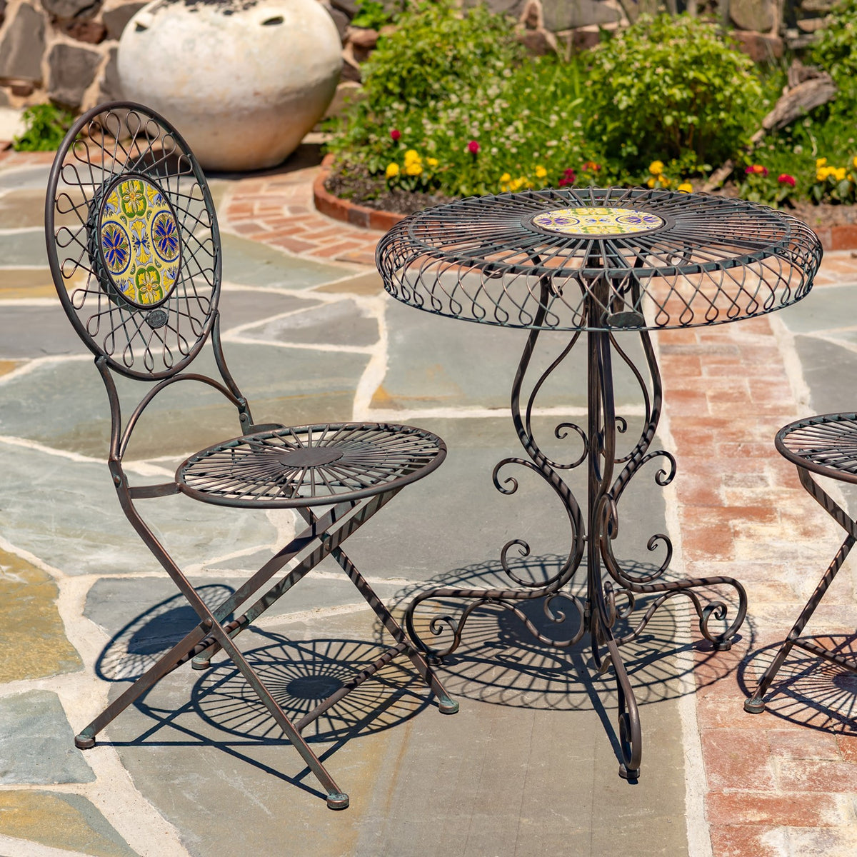 Closer view of the round table and ornate wire chair frames, with colorful tile centers.