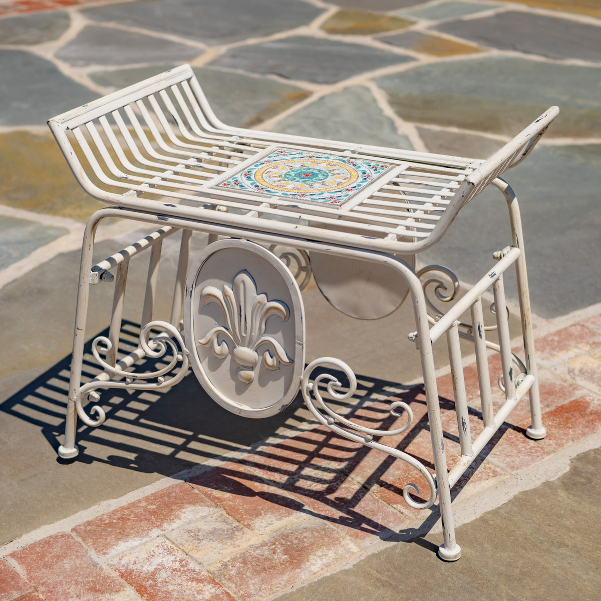 The chair is viewed from the opposite side, showing its slatted seat, mosaic center, and decorative oval panel.