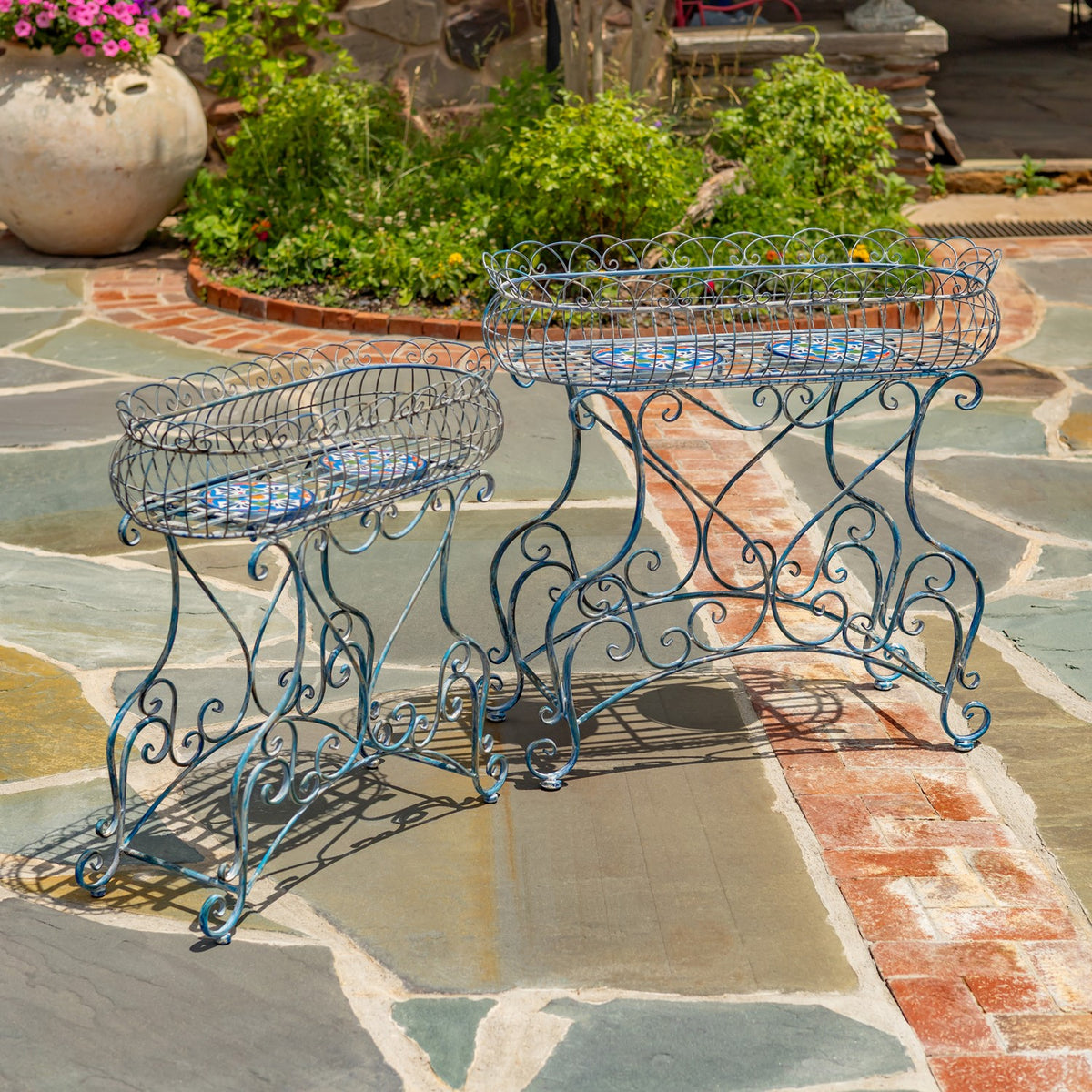 Two empty oval wire baskets sit atop blue stands with curling metal legs.