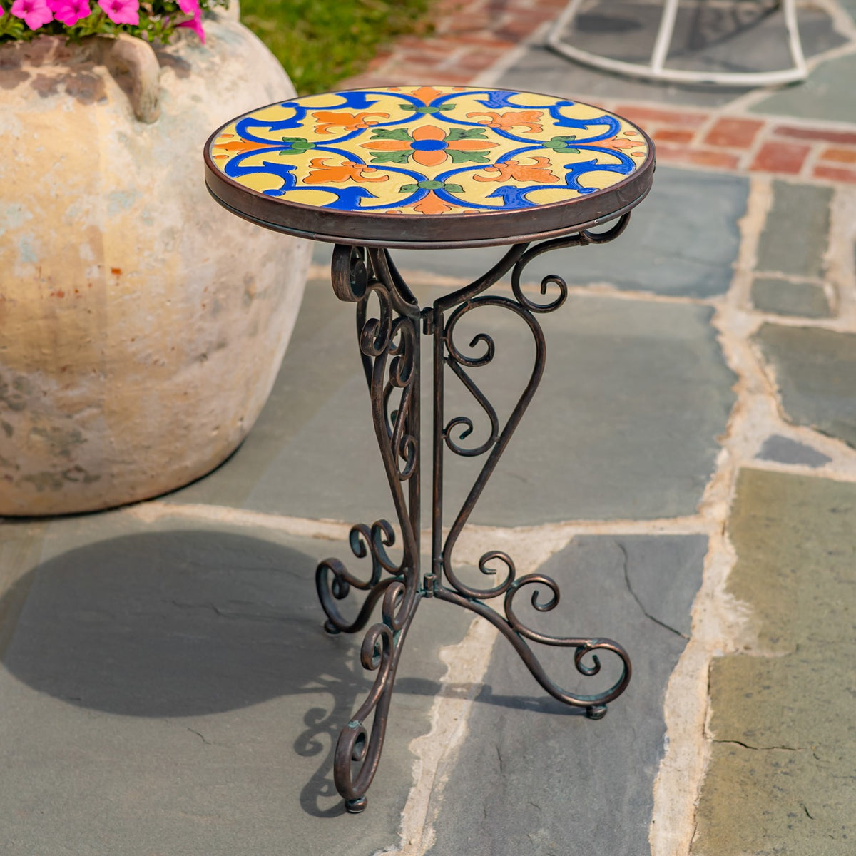 Mosaic-topped stand viewed from above, showing its dark metal scrollwork legs.