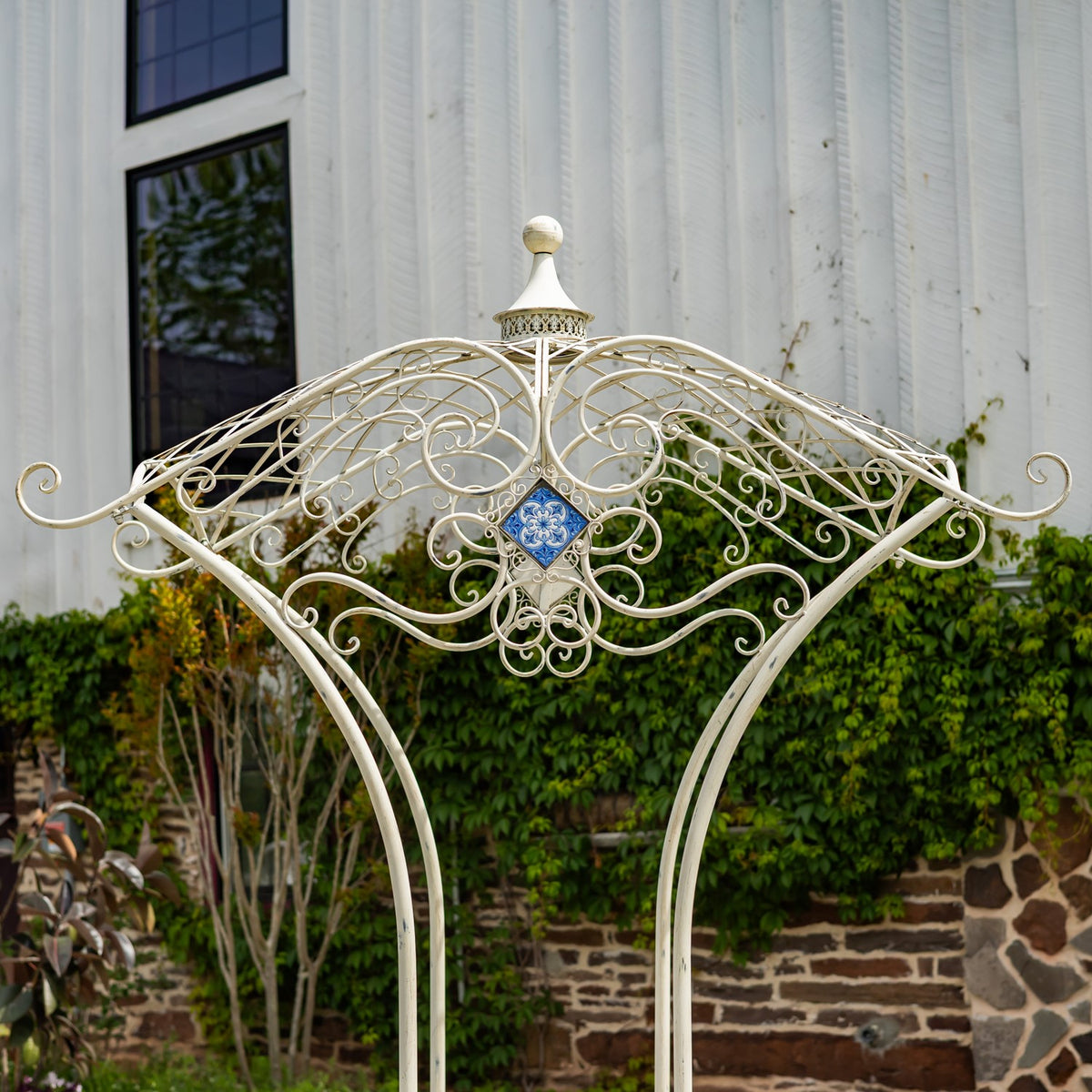 Close view of the bridge’s curved metal arch, intricate scrollwork and small blue diamond-shaped mosaic.