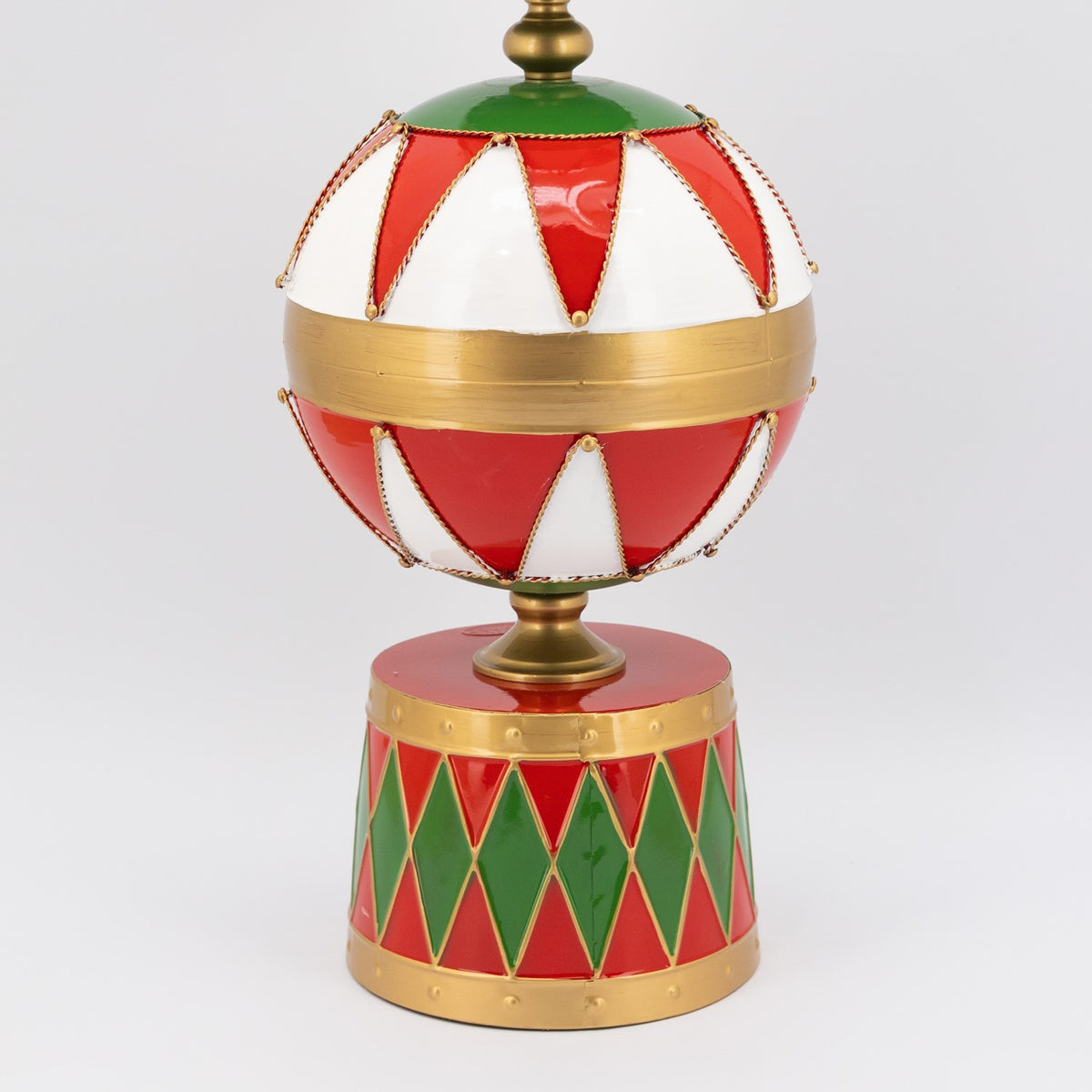 Close-up of the tower’s diamond-patterned red and green base beneath a large striped ornament.