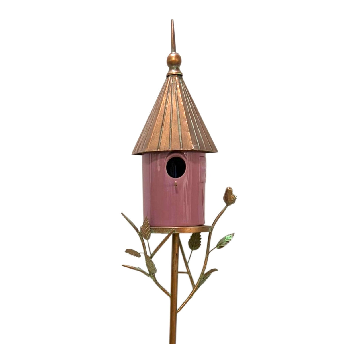 Closer view of the pink birdhouse, pointed metal roof and decorative leaf branches against white.