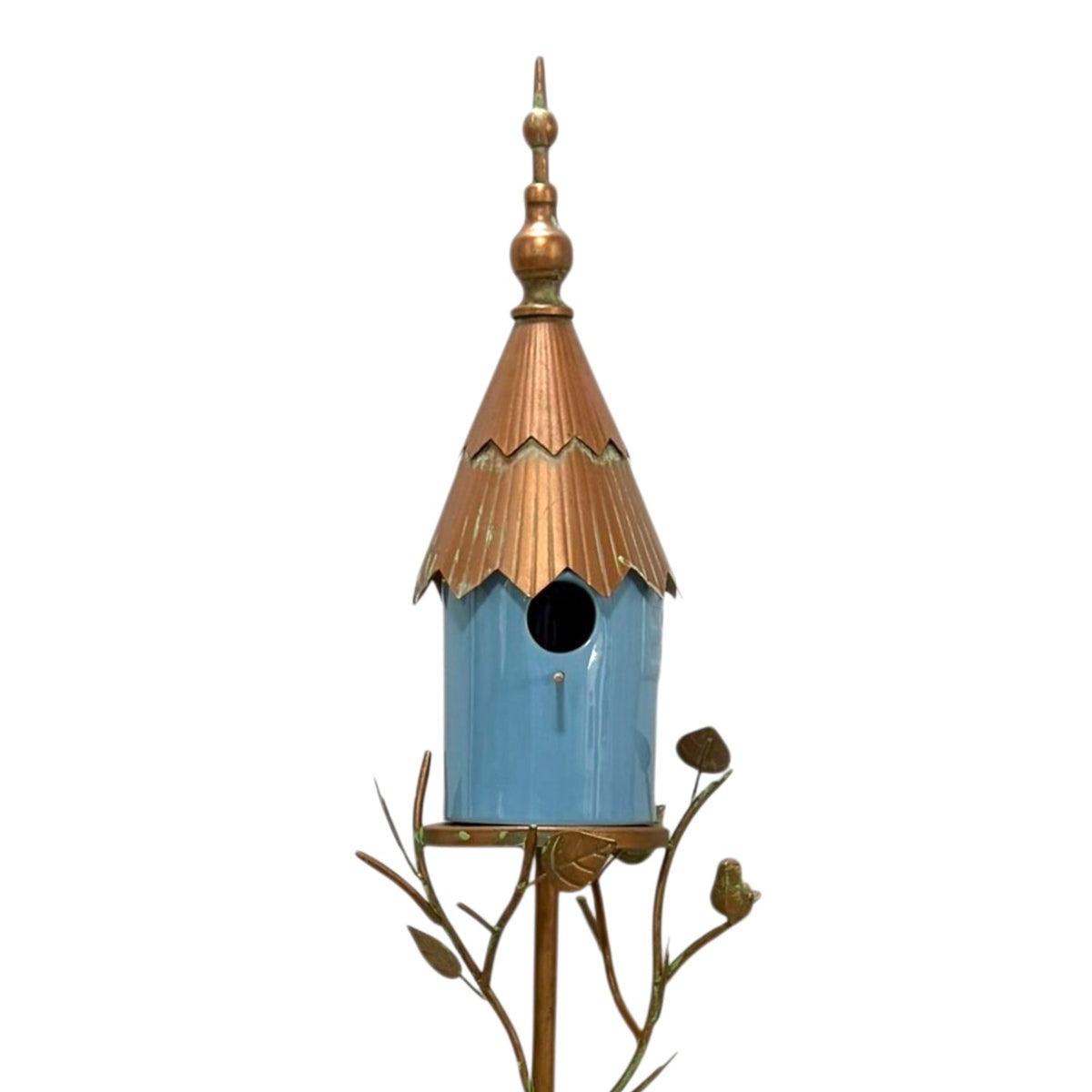 Close view of a blue birdhouse with a scalloped copper-toned roof, mounted on decorative metal branches.