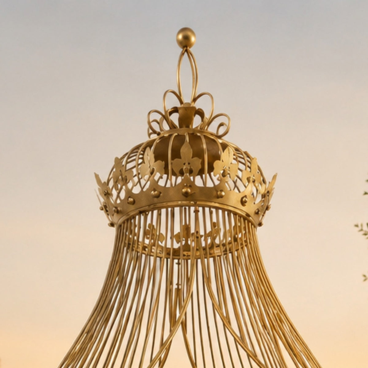 Close-up of the pavilion’s ornate gilded crown, with curled metal loops and a round finial.