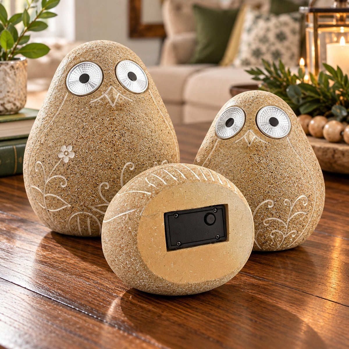 Two upright bird ornaments flank a third turned over to show its dark rectangular underside panel.