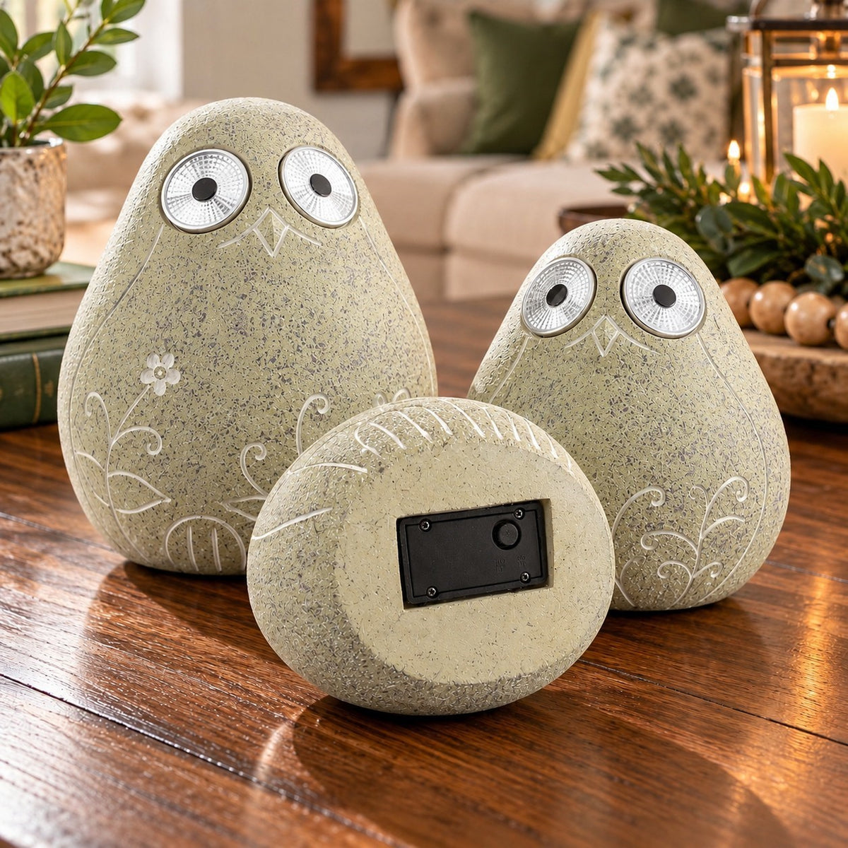 Two etched bird ornaments stand behind a third turned over to show its black underside panel.
