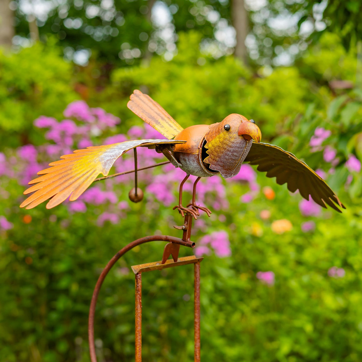 Orange and yellow metal bird stake shown from the front in a garden