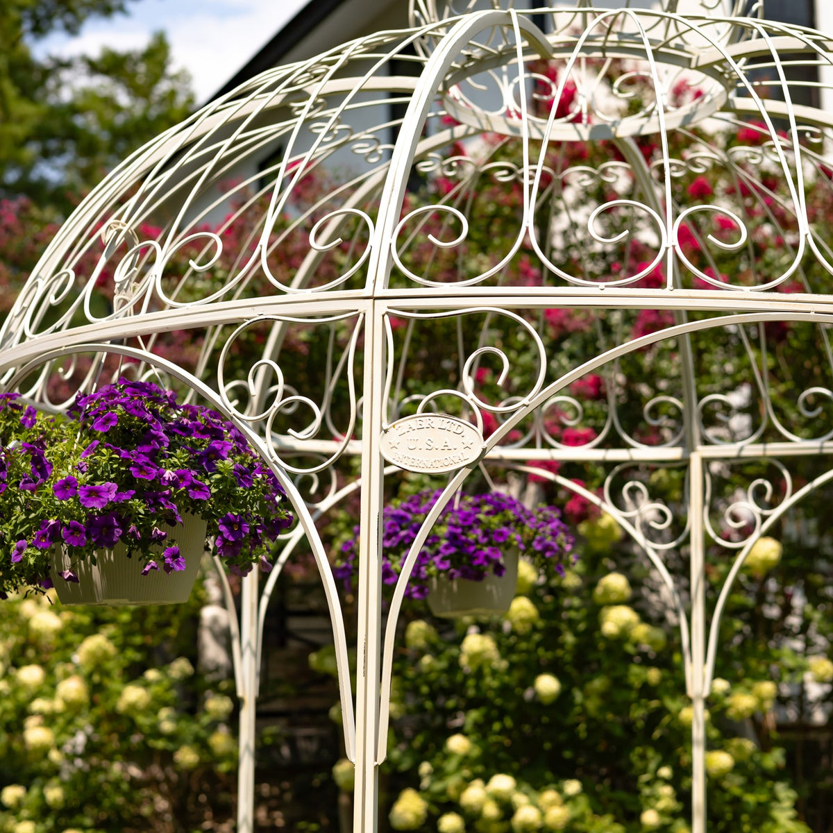 Close detail of white gazebo scrollwork and hanging flower baskets