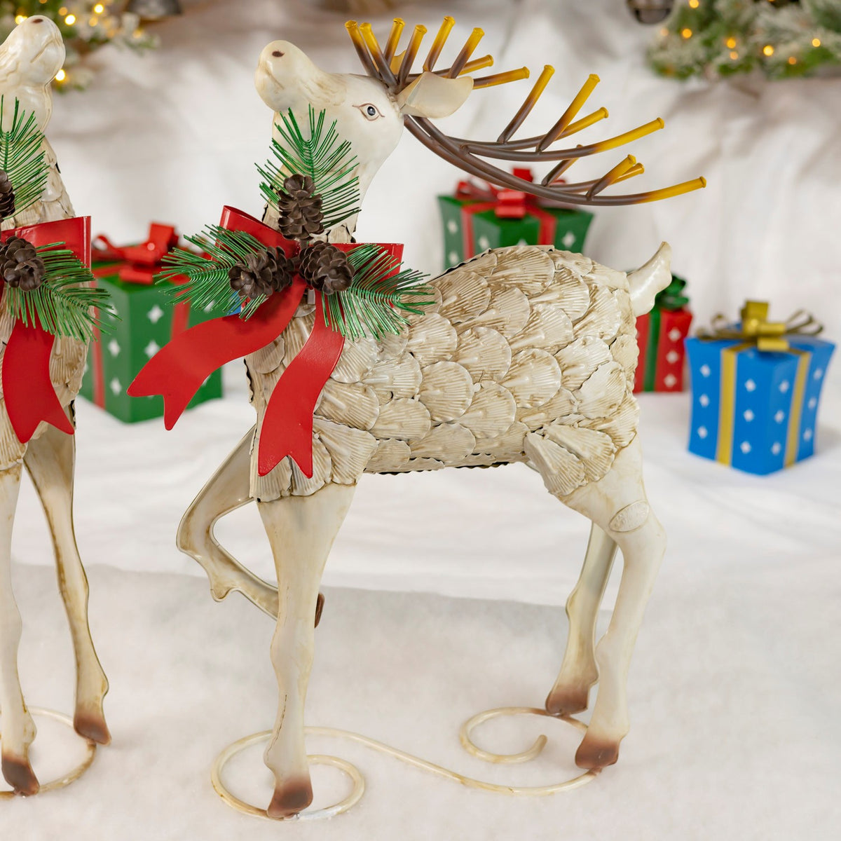 Cream iron reindeer with a red bow and antlers in a festive display
