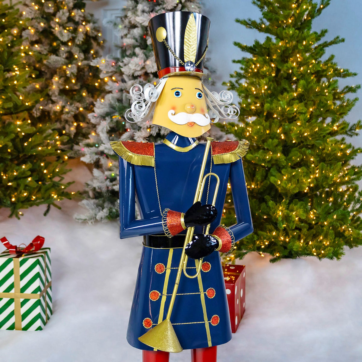Blue nutcracker soldier holding a trumpet, shown from the front among Christmas trees