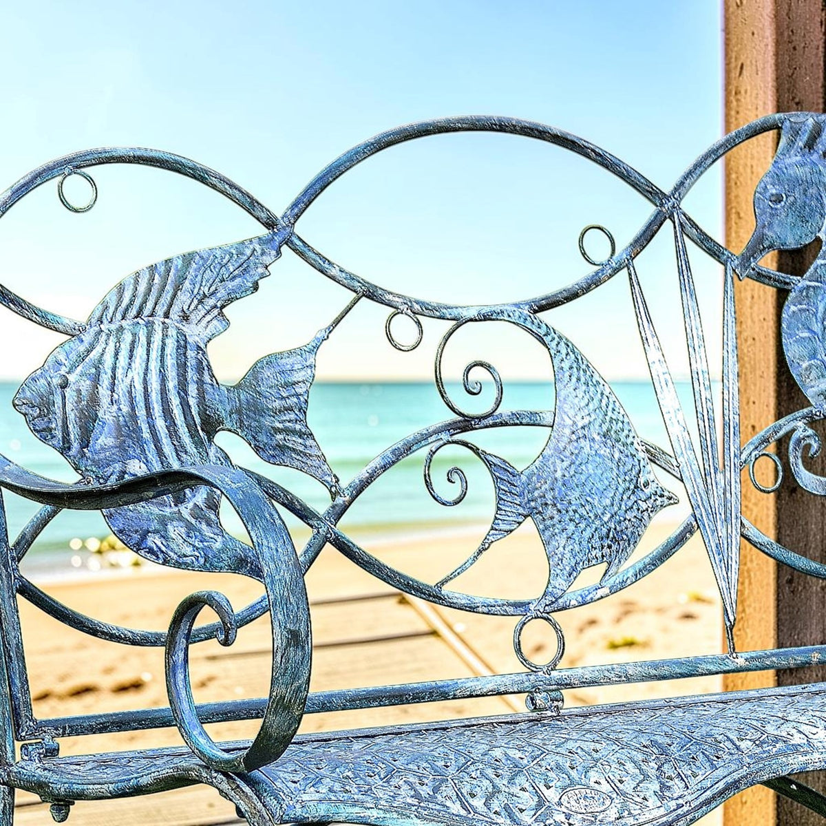Close view of blue iron fish and scrollwork across the bench back