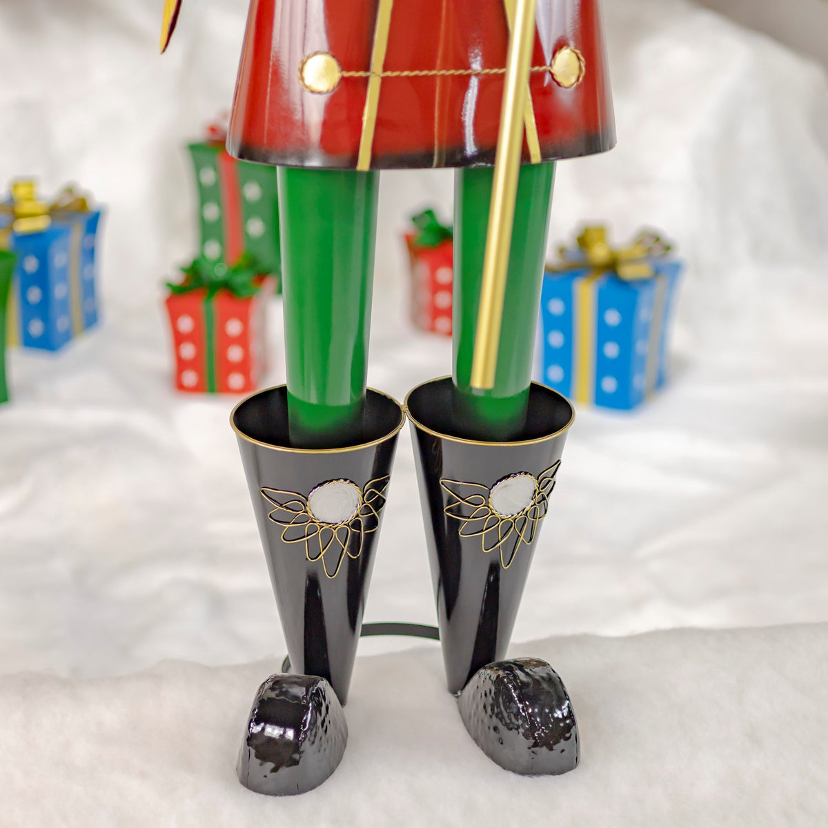 Close view of the nutcracker's green legs and black boots with gold detailing