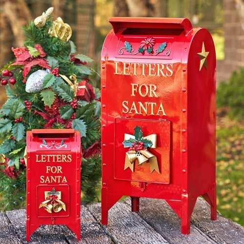 Small and medium glossy red mailboxes with gold stars and holiday decorations on a garden path