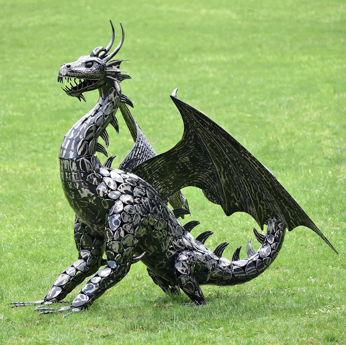 Dragon statue posed with its wings extended, one foreleg raised, and its tail curling behind it.