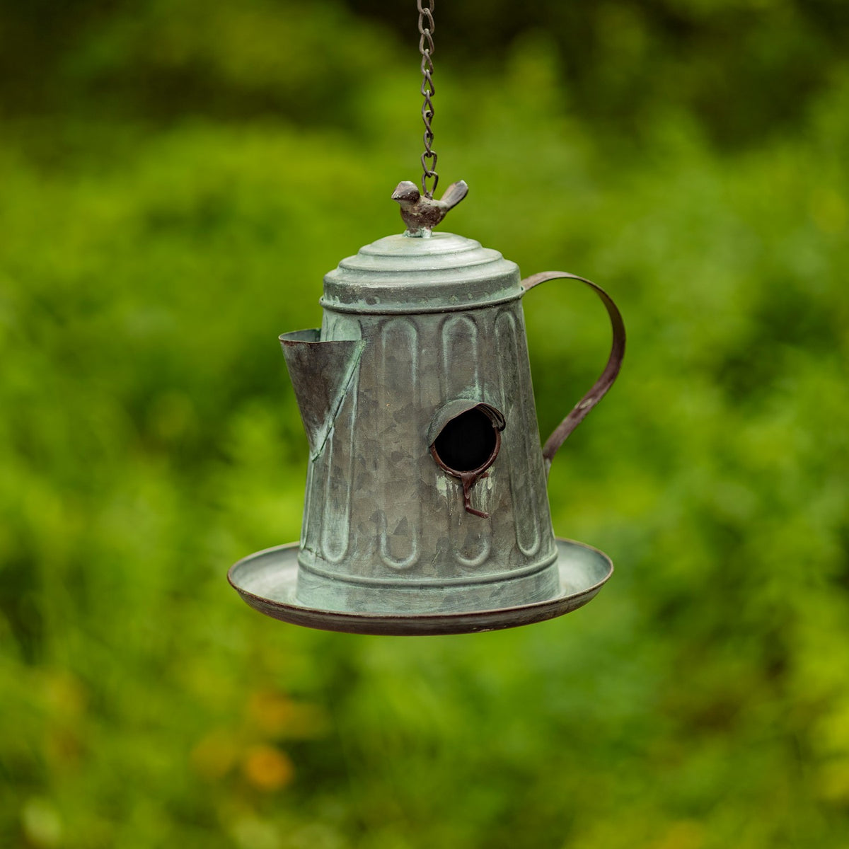 Fluted teapot birdhouse with a round entrance, side spout, curved handle, and bird-shaped top ornament.
