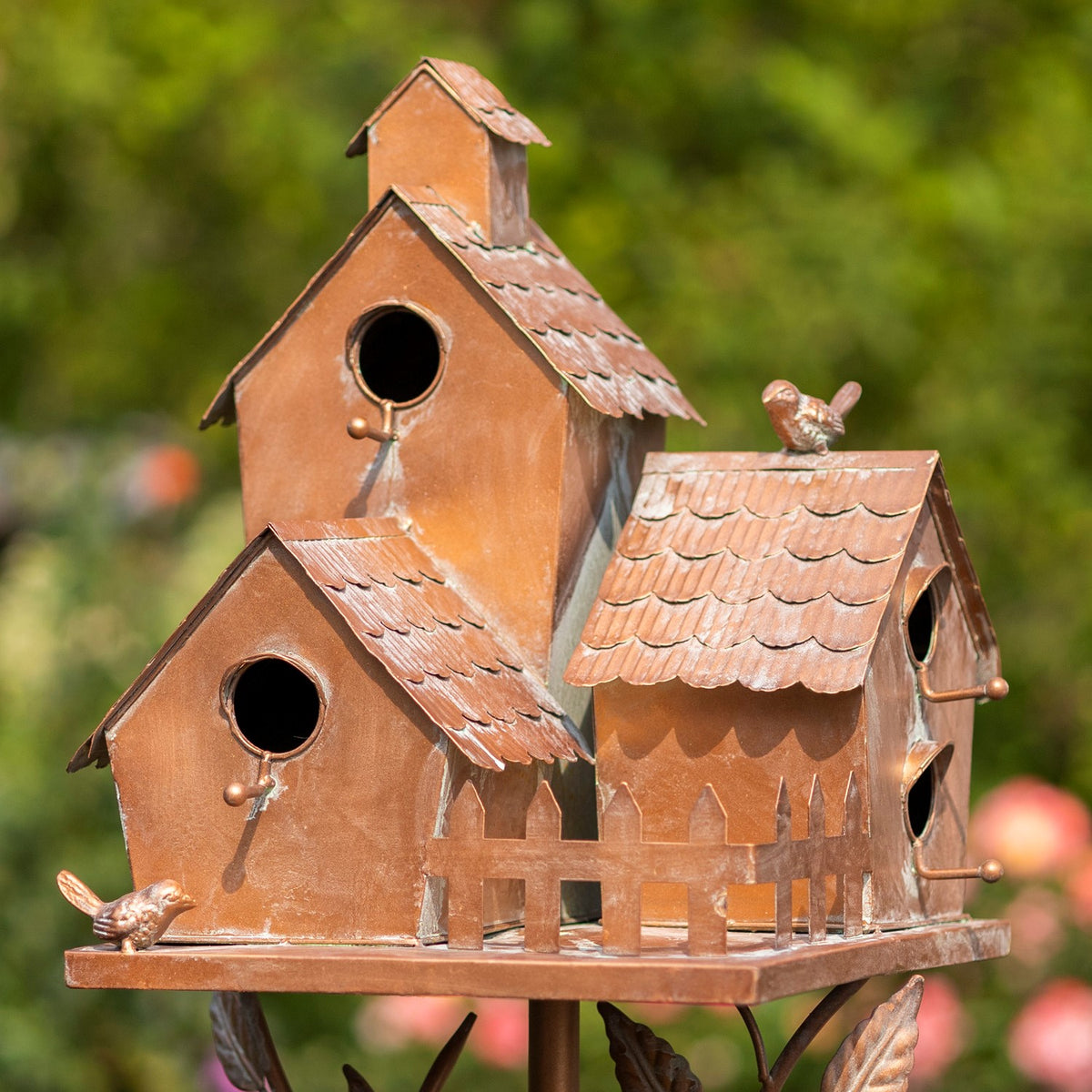 Close front angle of the copper-toned birdhouses, roof details and entry holes