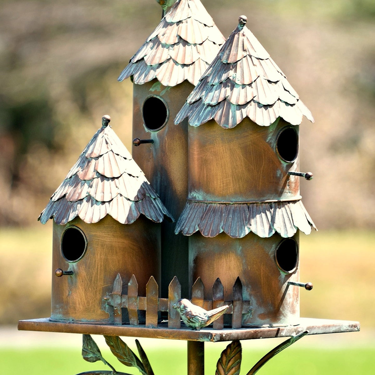 Close view of the birdhouses’ round openings, layered roof scales, tiny perches, and miniature fence.