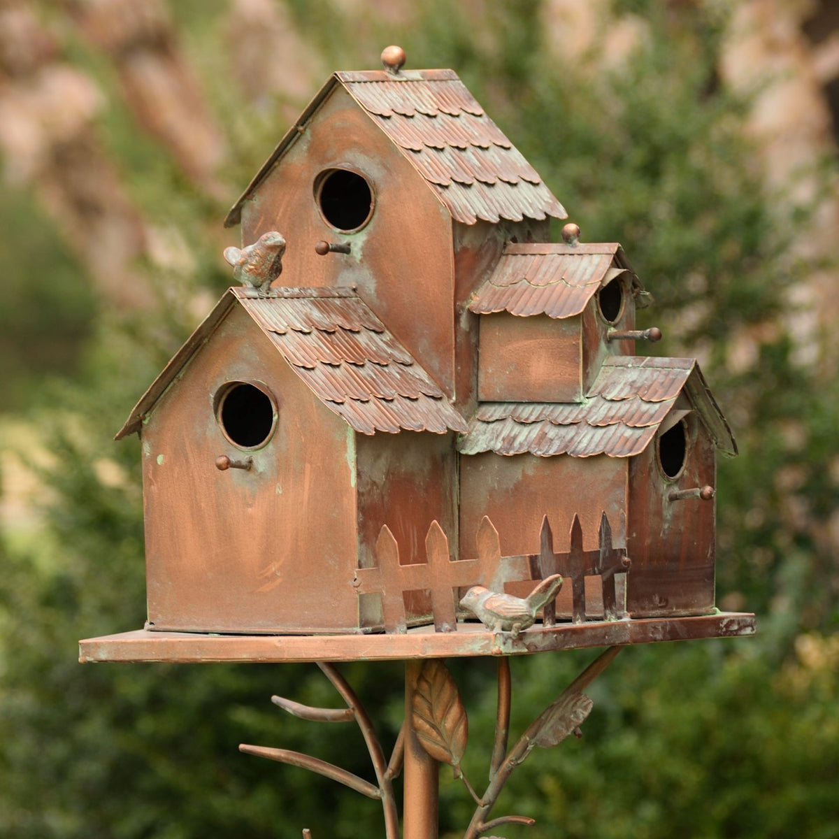 Front view of an antique copper birdhouse stake with shingle-like roof details