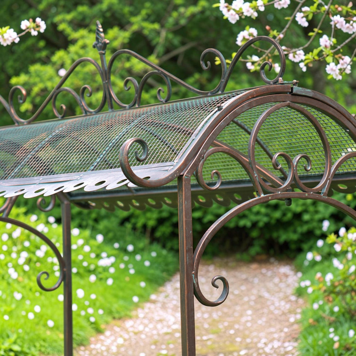 Close-up of the arched mesh roof, scrollwork trim and curved iron supports.