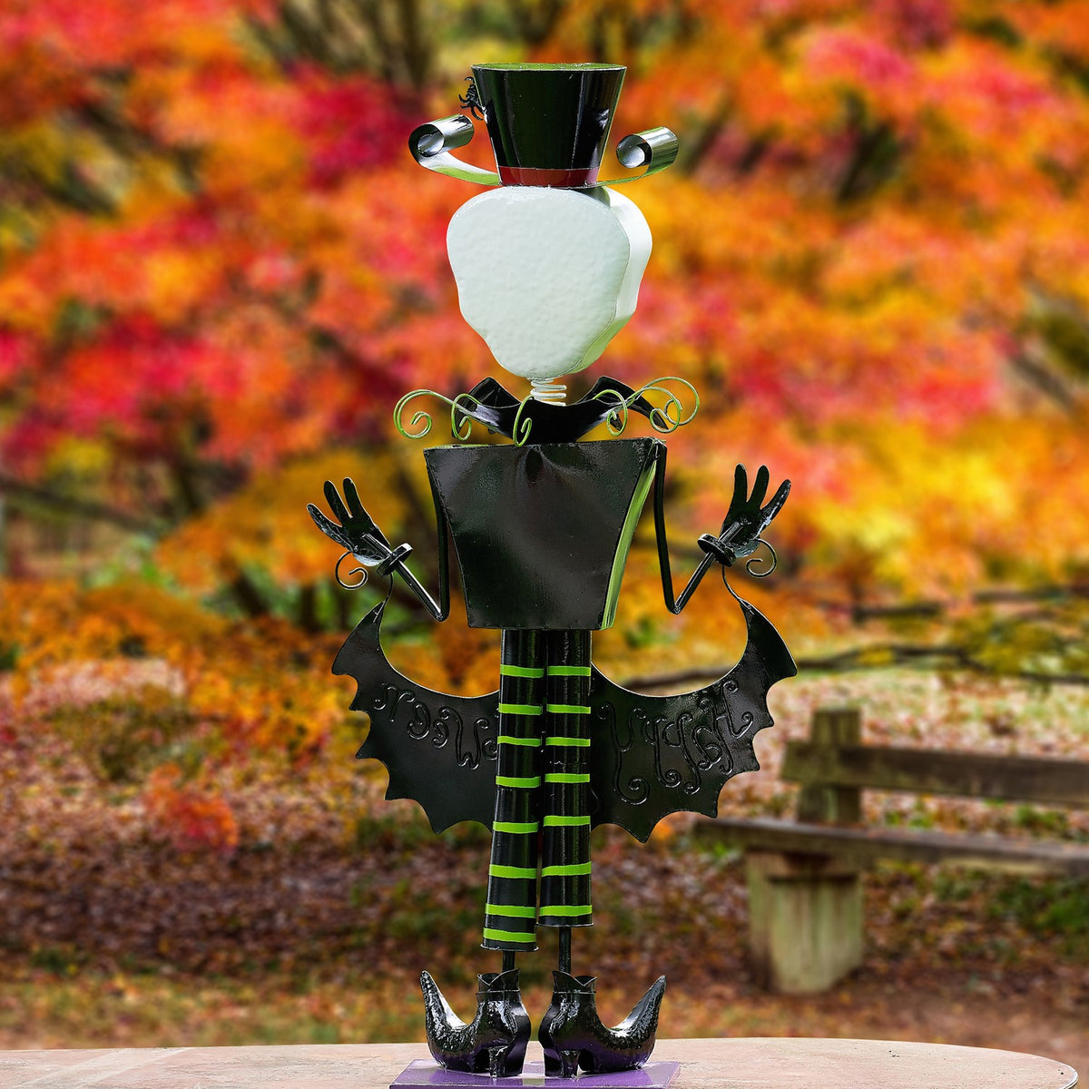Back of the skeleton figurine, showing its black coat, striped legs, and the reverse of its bat-shaped sign.