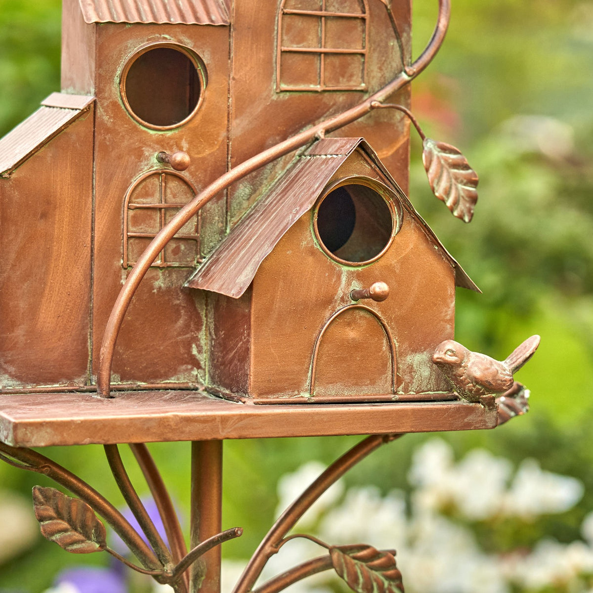 Close-up of copper-finish birdhouse rooms, entry holes and decorative perches