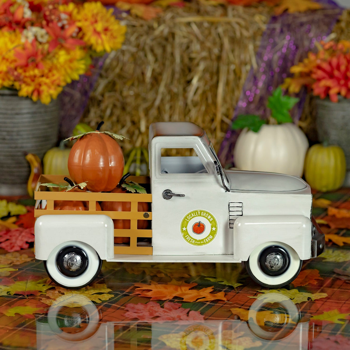 Side profile of the pickup with wooden bed rails and pumpkins, set against fall foliage.