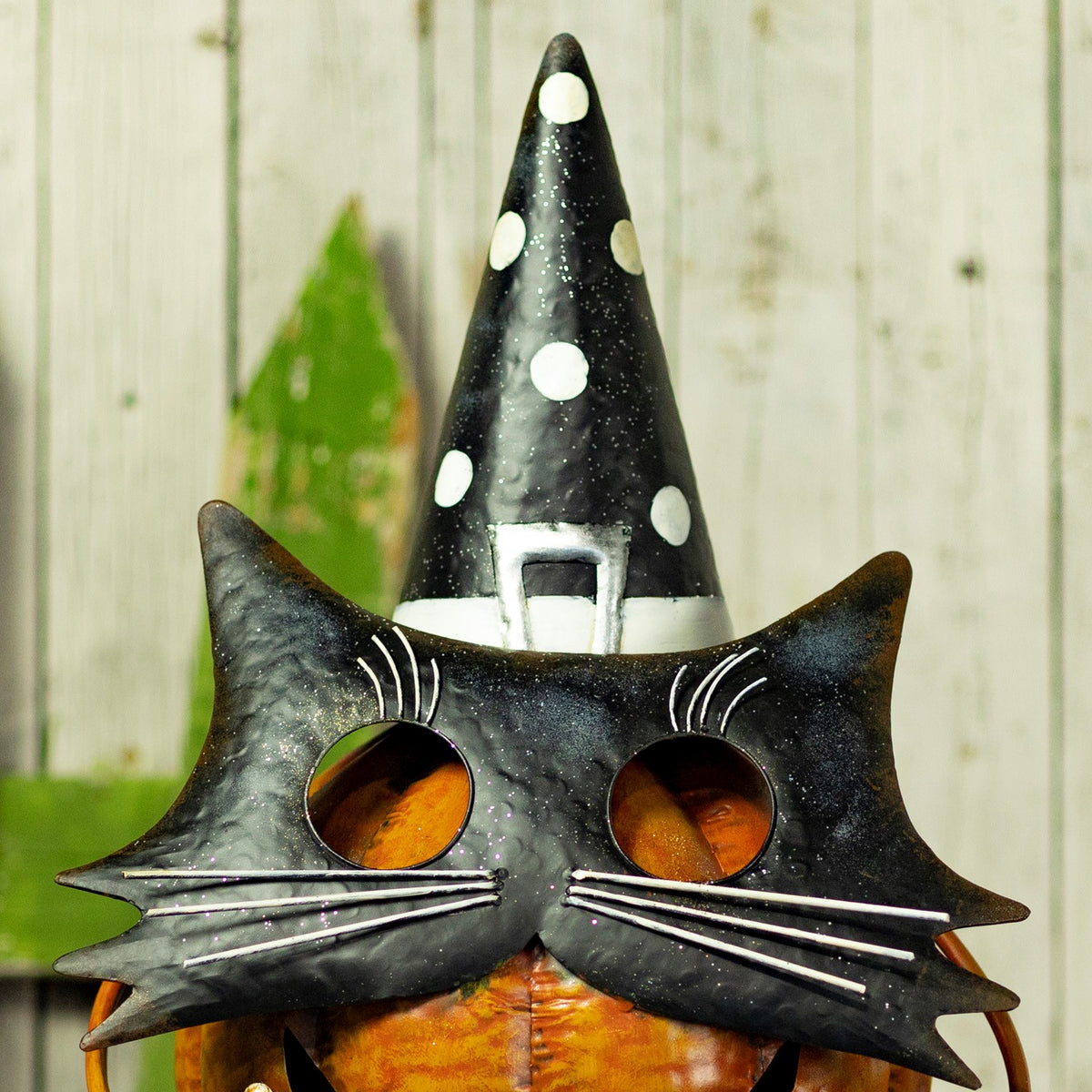 Upper view of the figurine with black cat face and tall polka-dot witch hat