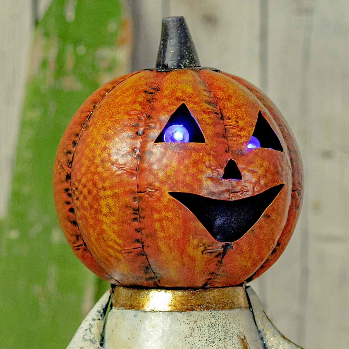 Close-up of the orange jack-o'-lantern face with glowing purple LED eyes