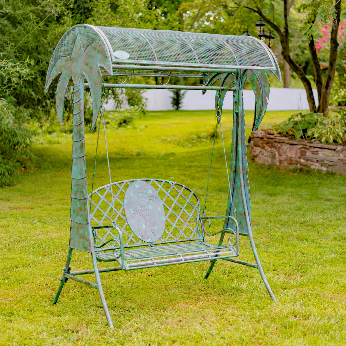 Front view of the green iron swing bench in a garden setting