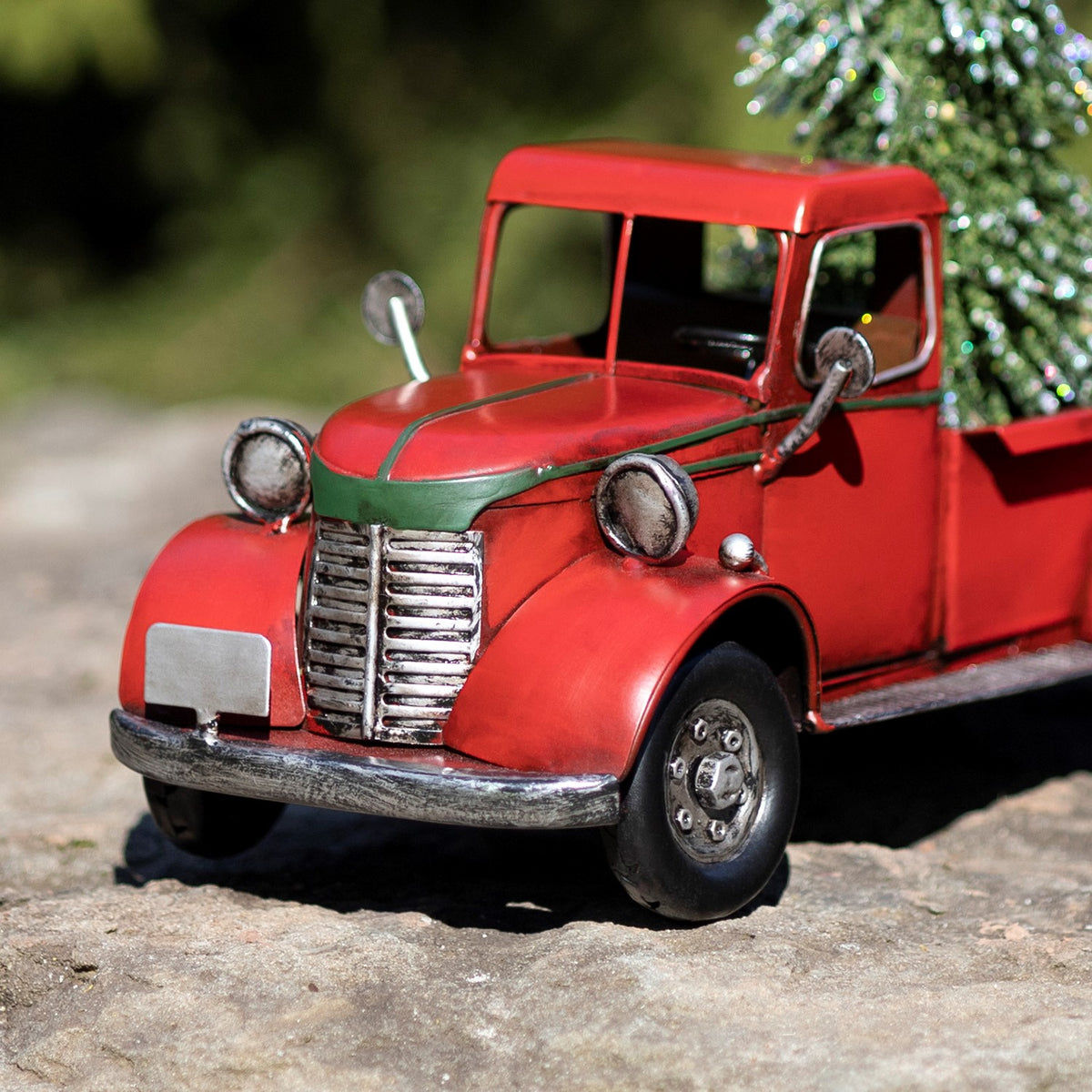 Close view of the truck’s rounded hood, chrome grille, headlights, windshield, and front wheel.