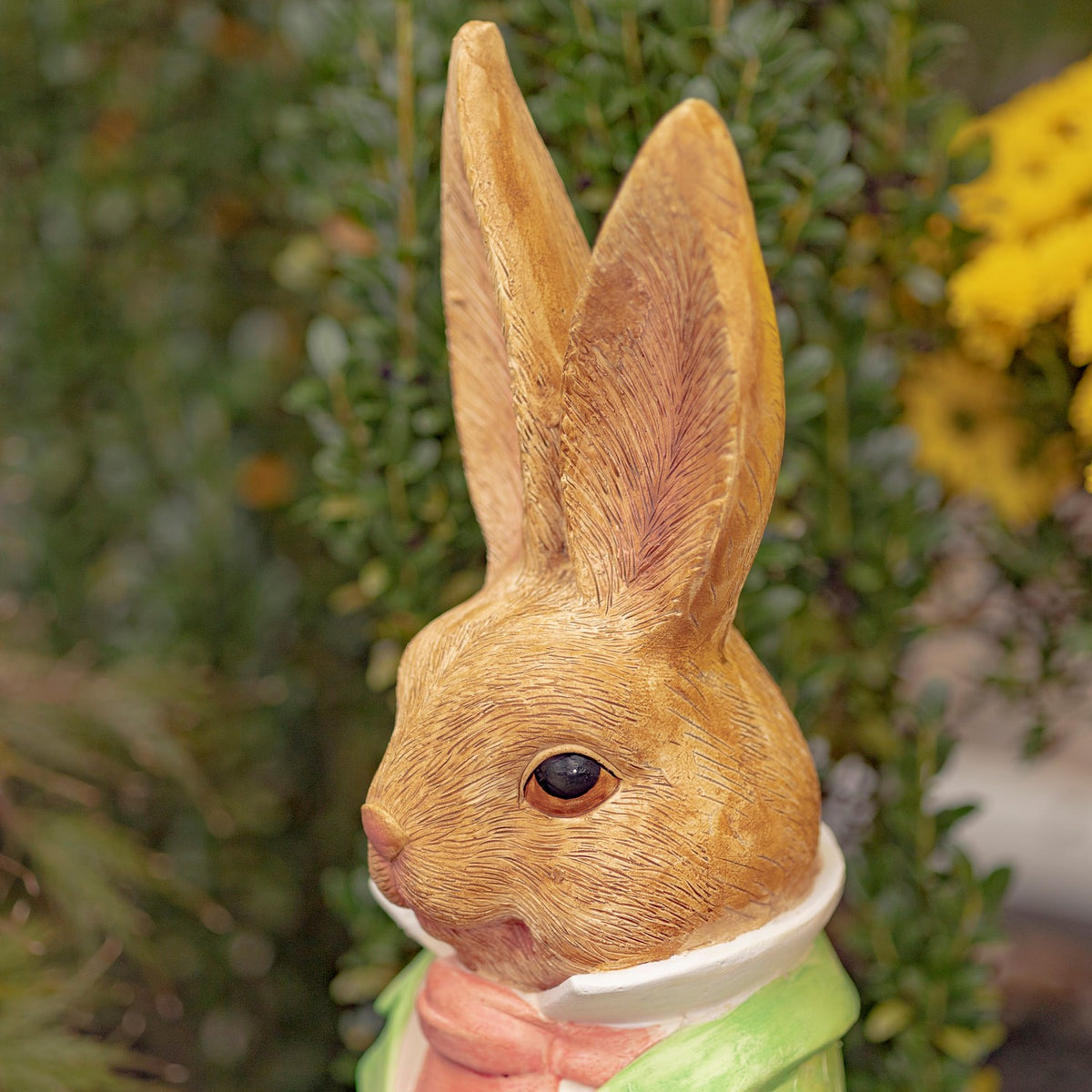 Close-up of the rabbit’s textured face, tall ears, and pink necktie.