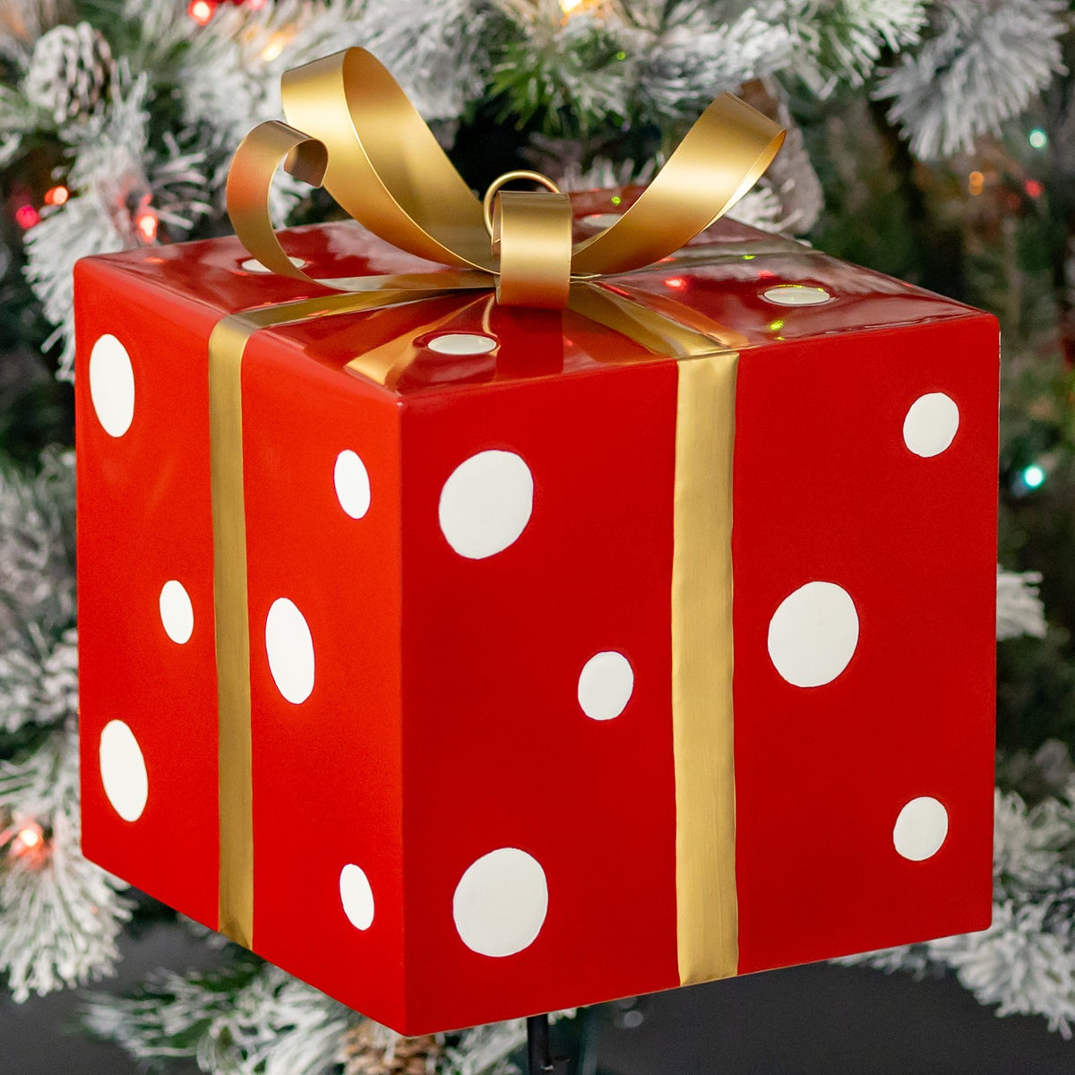 Close view of the glossy red box with white dots, gold ribbon and curled bow.