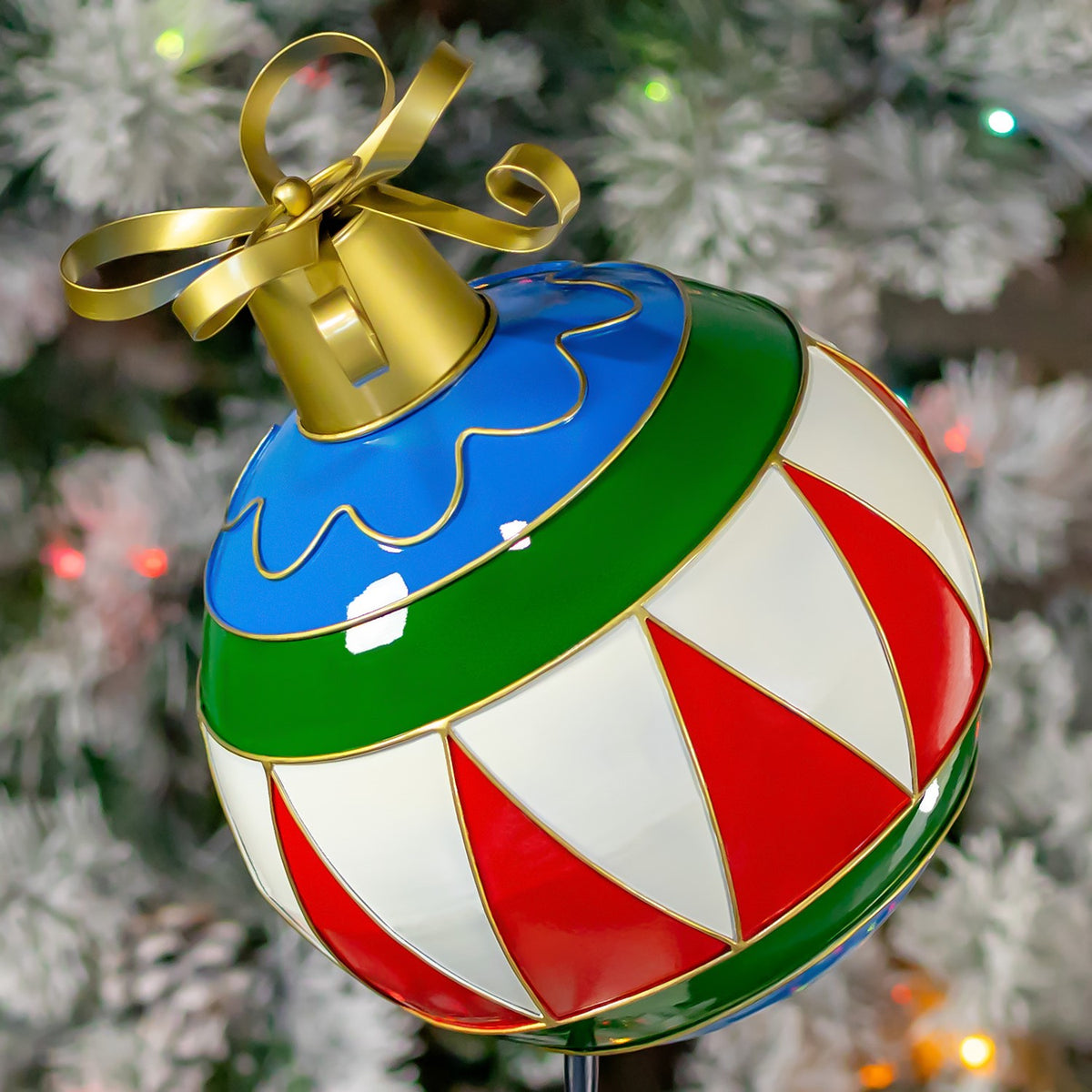 Close view of red-and-white panels, a green band, and gold-edged blue top on the ornament.