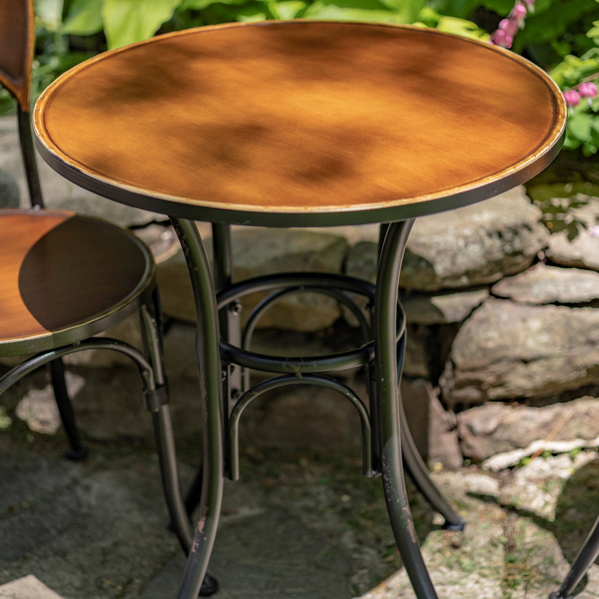 Close-up of the antique copper round tabletop and dark iron legs