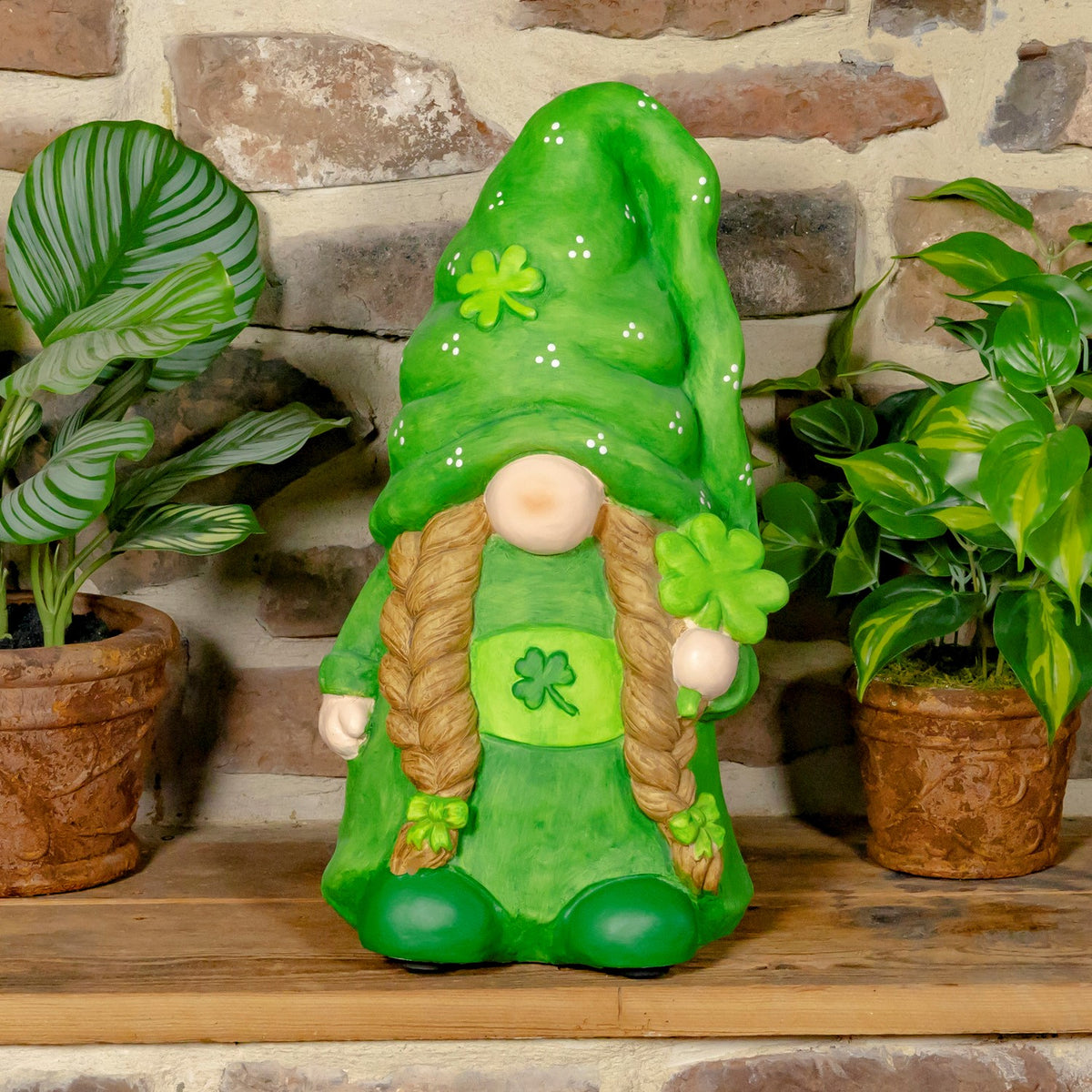 Green gnome with brown braids, a shamrock on its tunic, and a tall pointed hat.