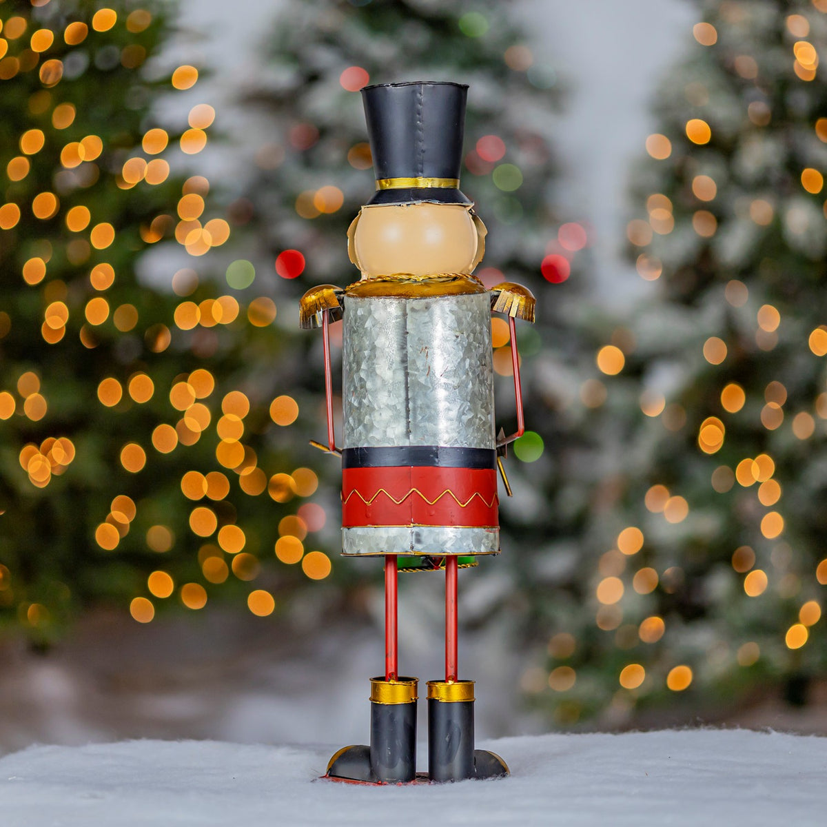 Full-length rear view of the nutcracker against a snowy holiday backdrop