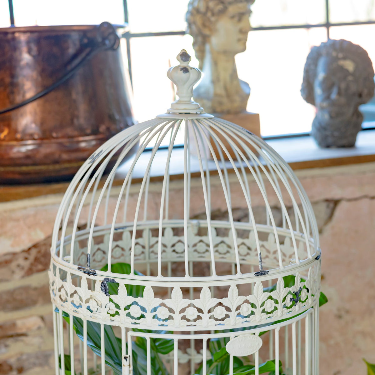 Close-up of the domed top and iron bars on an antique white birdcage