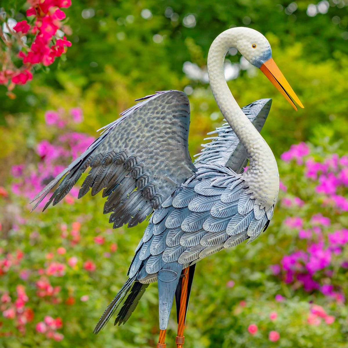 Close angled view of a blue-grey heron figurine with spread wings