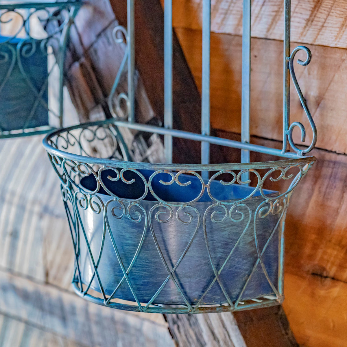 Close-up of a blue removable planter basket, showing its liner and curled metal wire pattern.