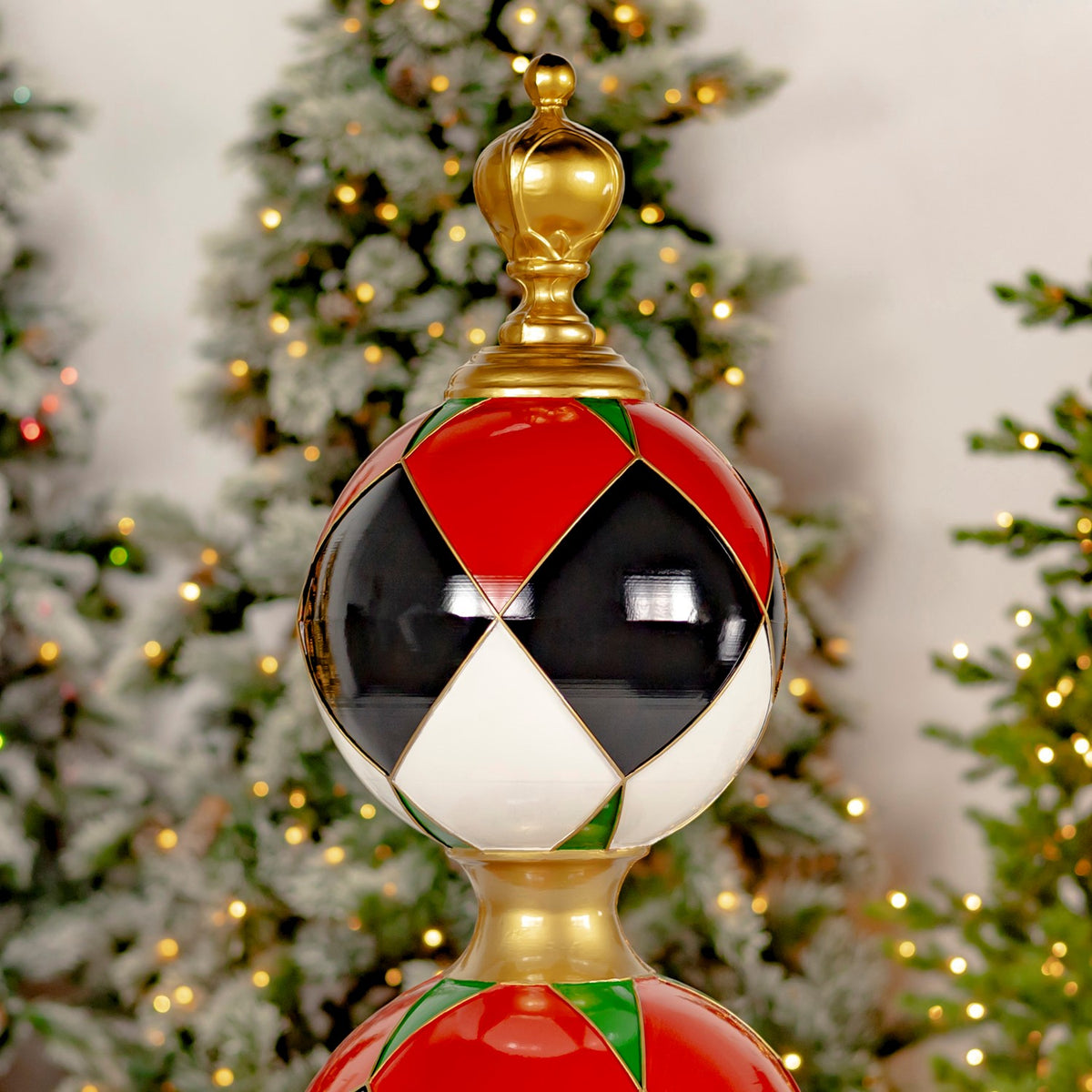 Close-up of the tower’s gold finial and glossy red, black and white geometric ornament.
