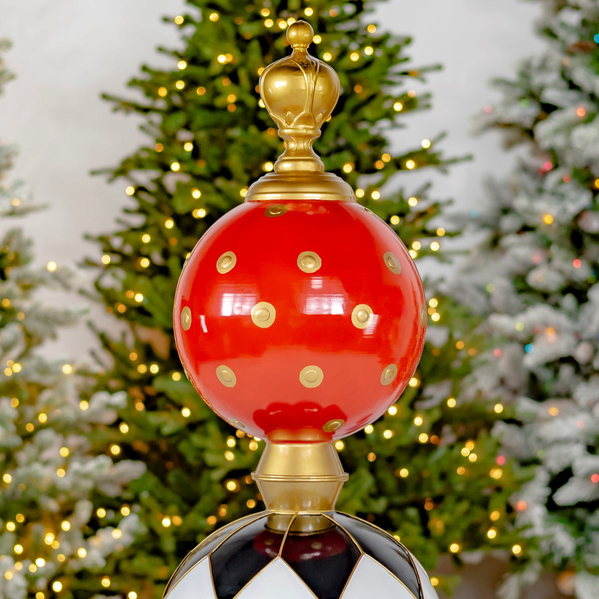 Close view of the tower’s red dotted sphere, gold finial, and black-and-white diamond-patterned sphere.
