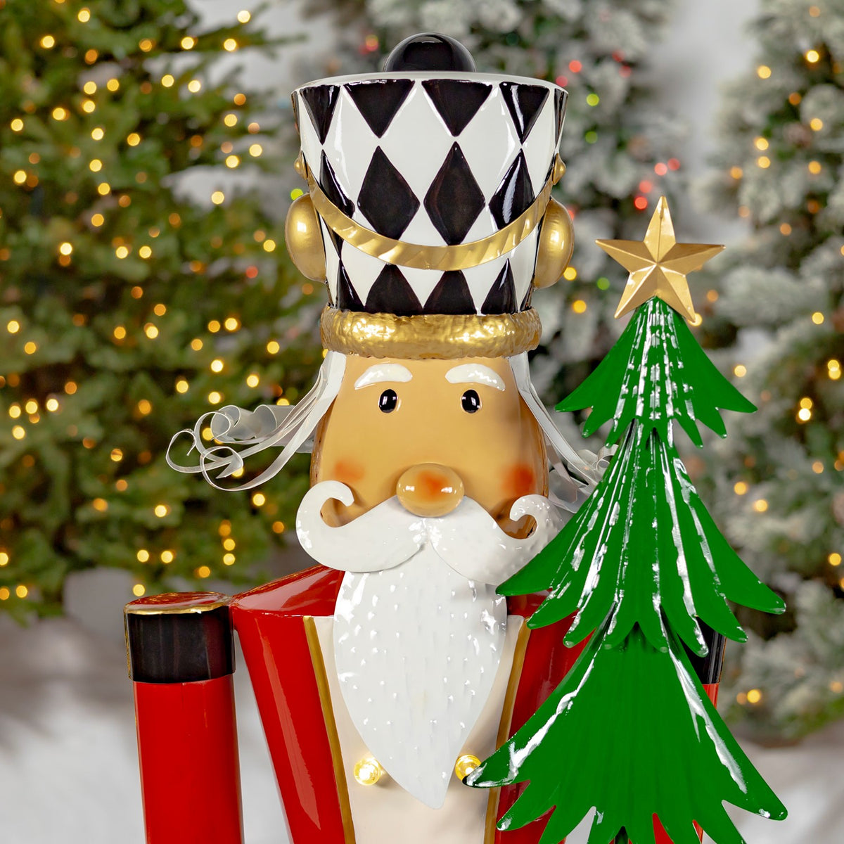 Close-up of the nutcracker’s diamond-patterned hat, face, white beard, and green tree.