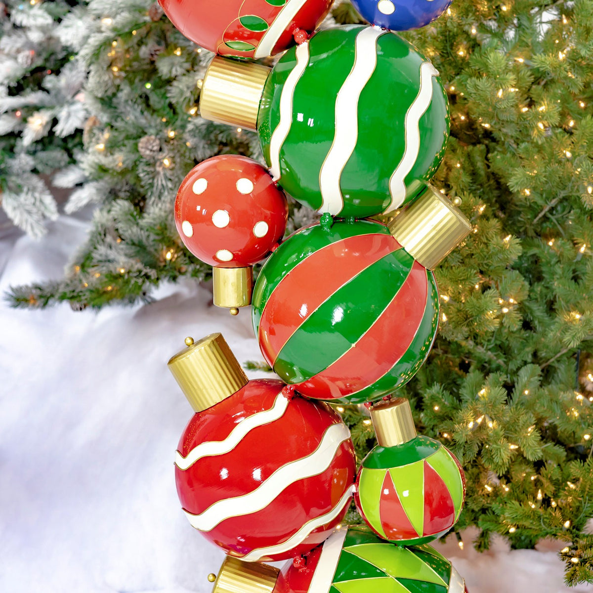 Close-up of red and green striped ornaments beside a decorated Christmas tree