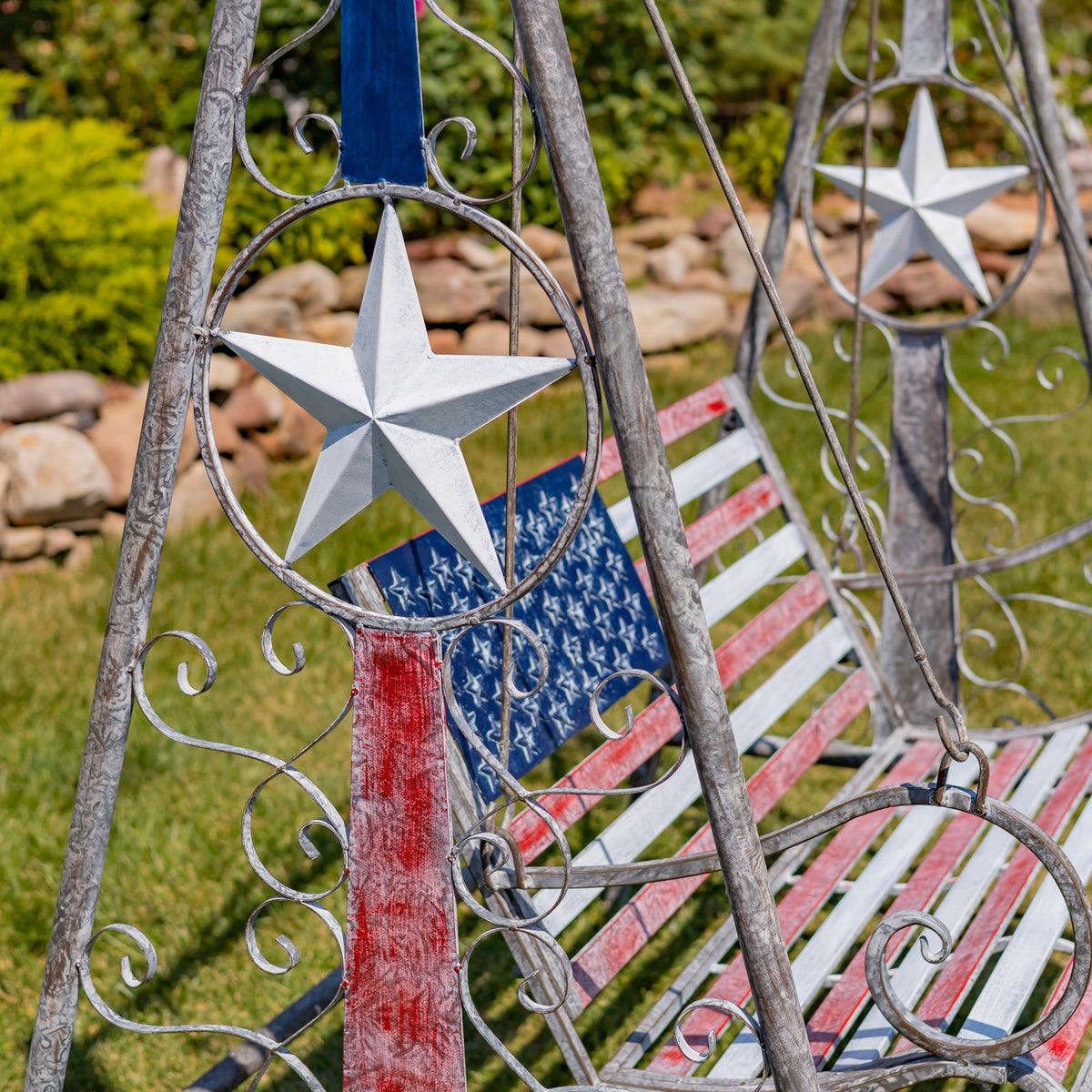 Close view of the flag-painted bench and star ornament on the iron frame