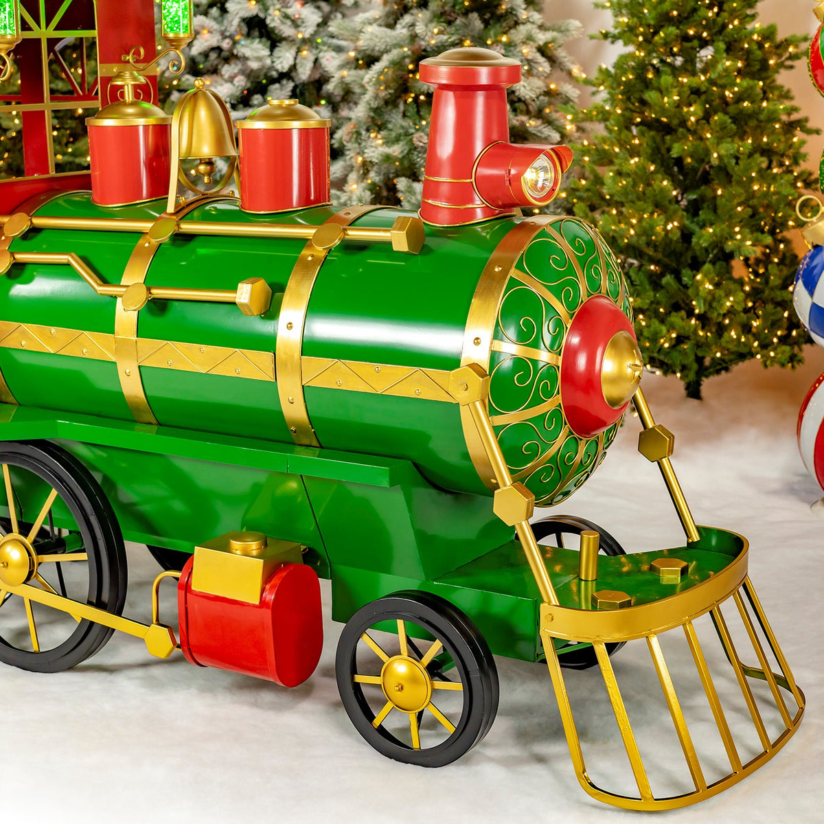 Close view of the green locomotive, gold trim and rotating black wheels