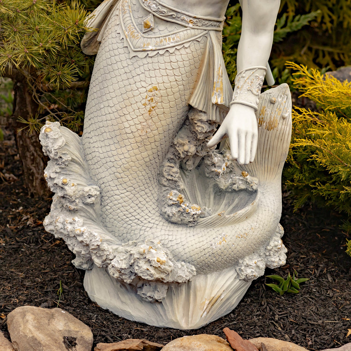 Close-up of the scaled tail, carved waves, and small gold-toned accents near the base.