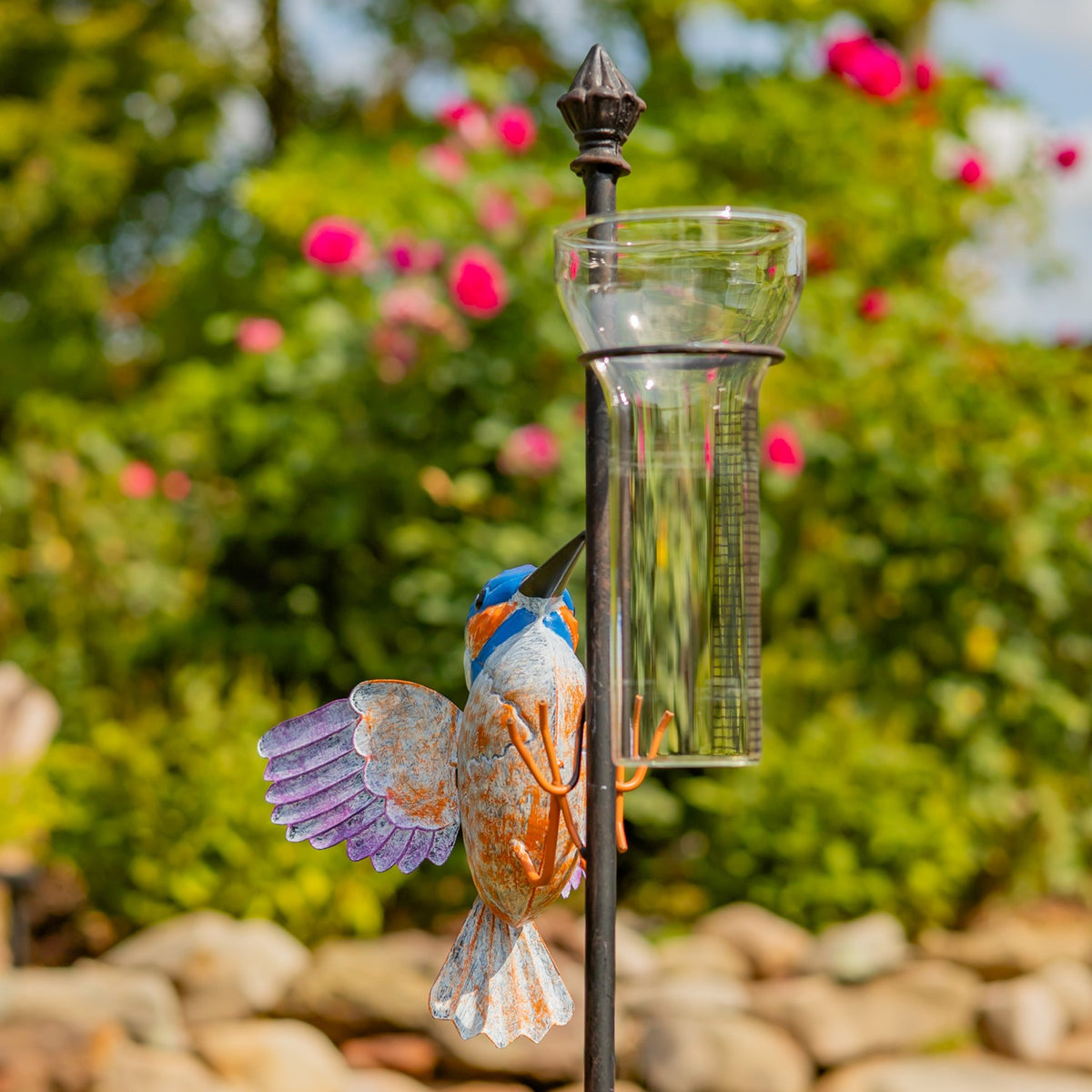 Close angled view of the glass rain gauge and painted hummingbird