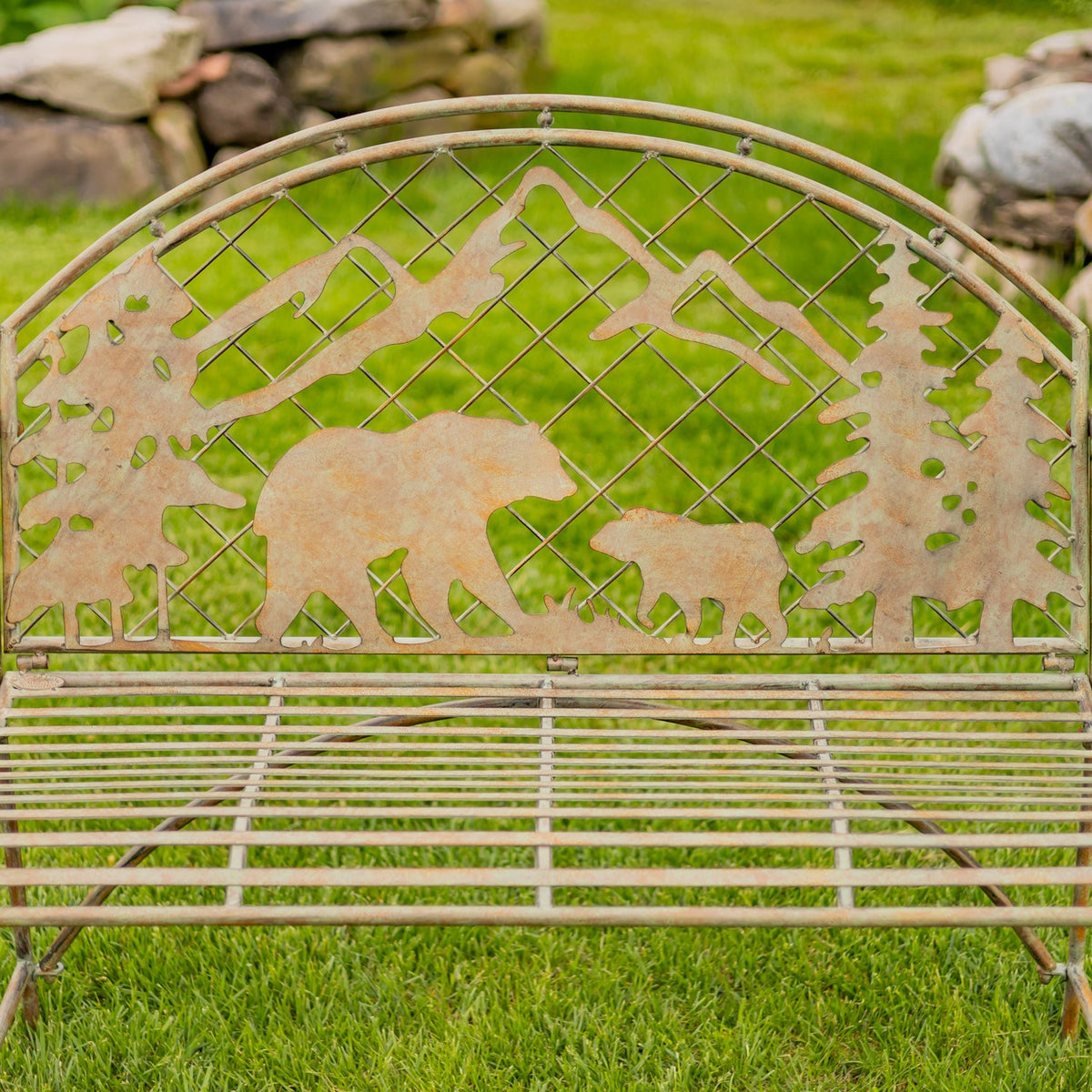 Bench backrest showing a bear and cub beneath mountain silhouettes against a crisscross metal grid.