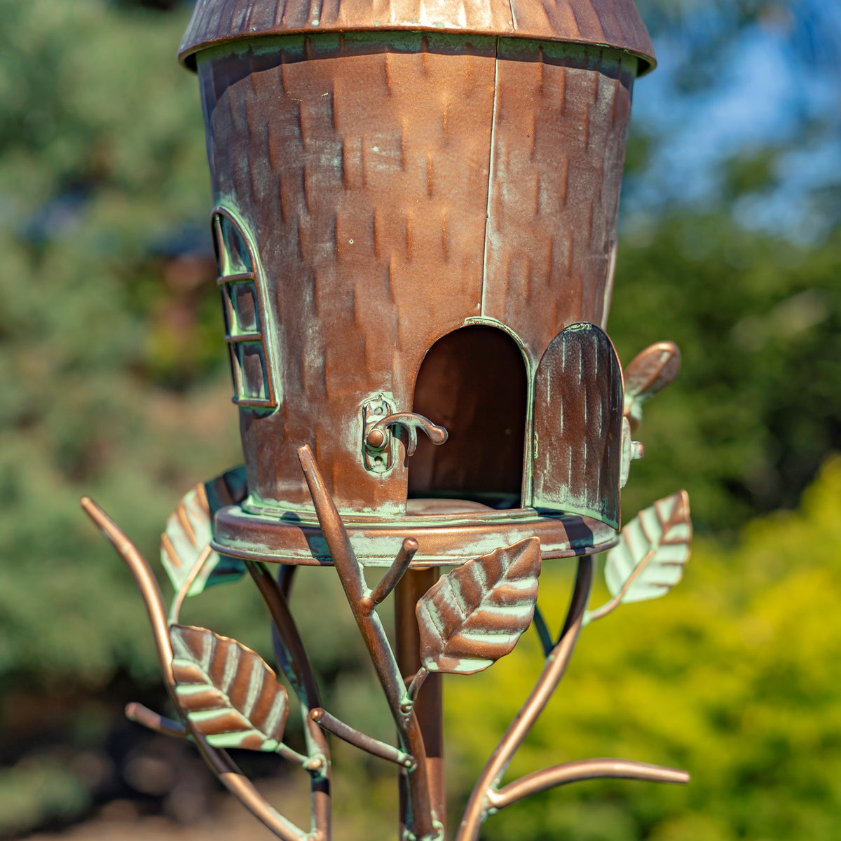 Close view of the copper birdhouse with its latched rear door open